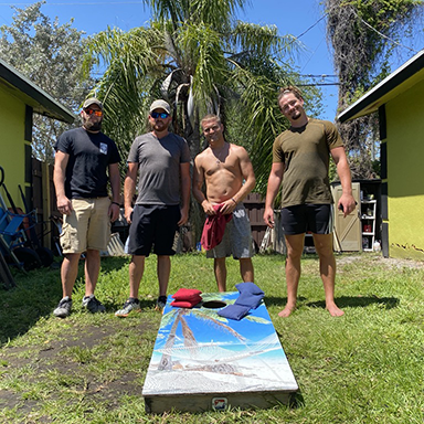 Men playing cornhole together at a sober safe space in Palm Beach County, building community and recovery support